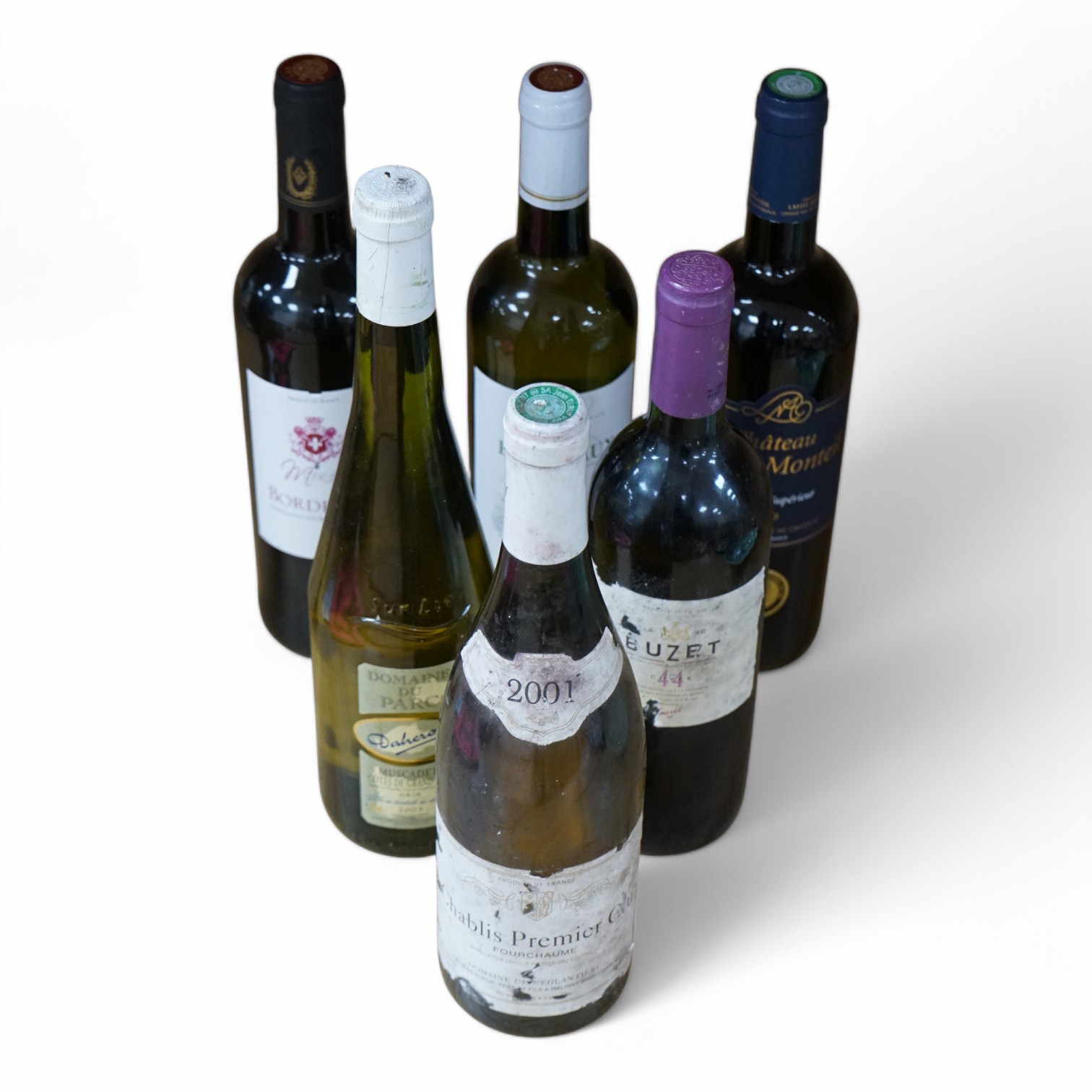 Six bottles of red and white wine to include Chablis Premier Cru 2001, Domaine Du Parc Muscadet 2003, Vin De Bordeaux, Chateau Lafite Monteil Bordeaux Supérieur 2020, Moncade Bordeaux and Buzet 1996. Condition - fair
